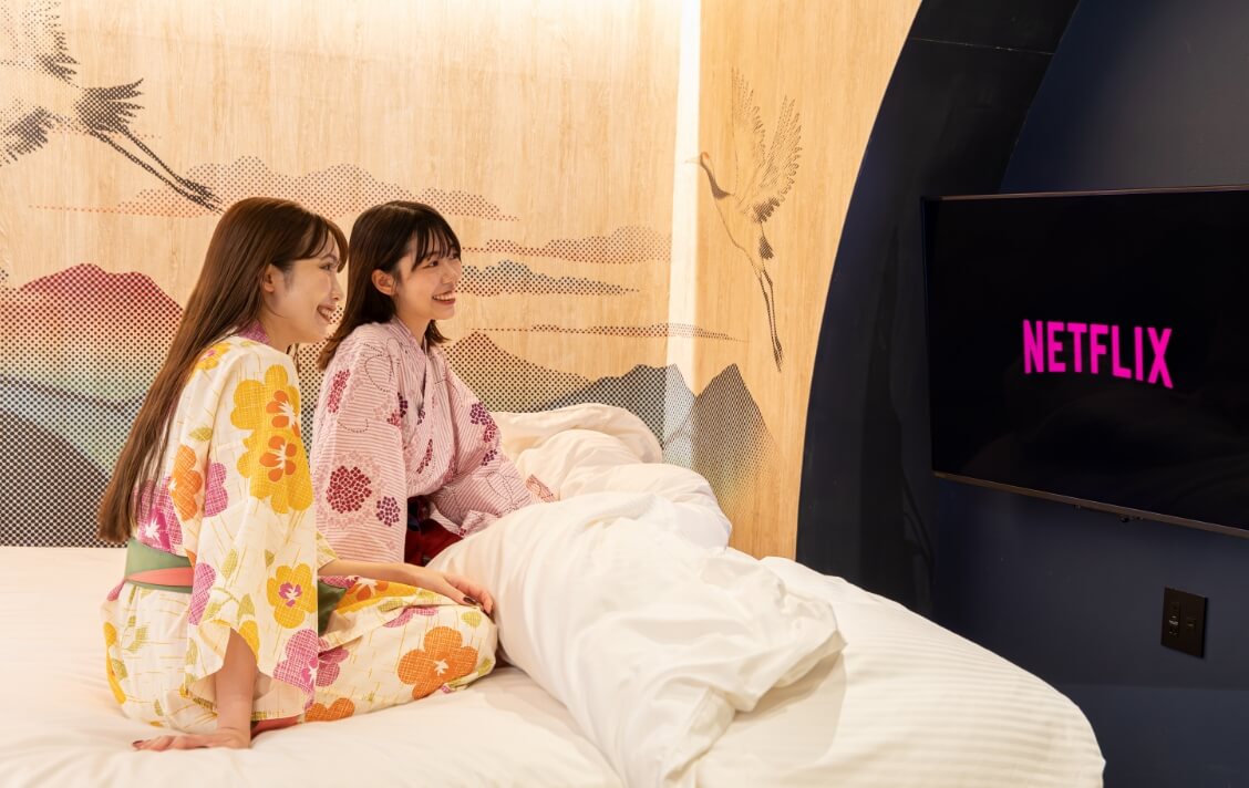 ベッドでくつろぎながらネットフリックスの動画を楽しむ様子