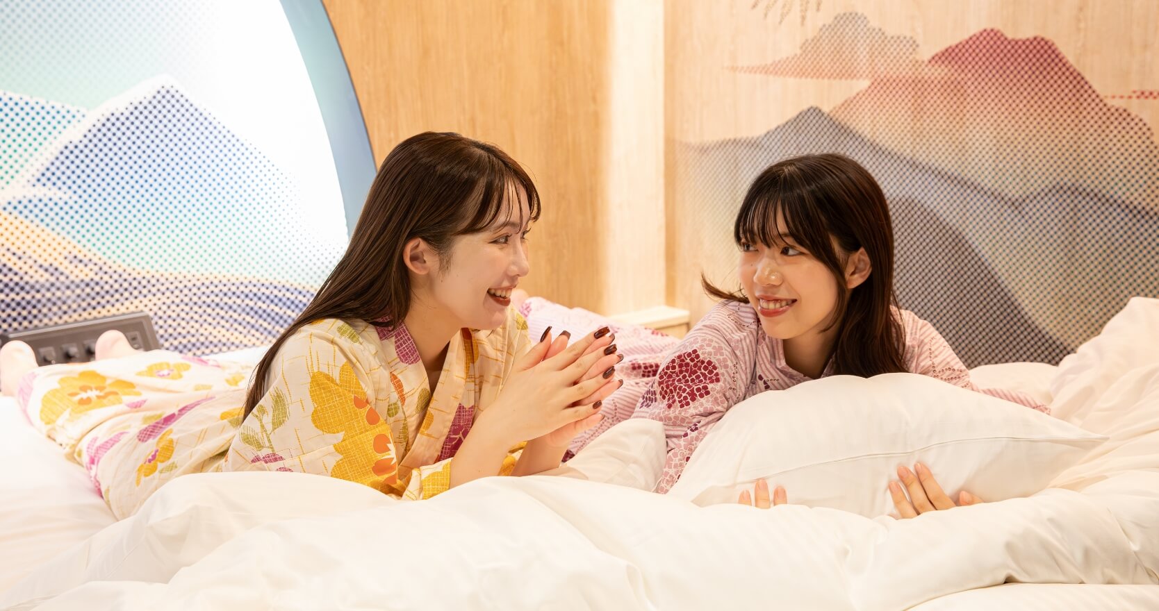 お部屋のキングサイズベッドでくつろぐ女性2人の様子