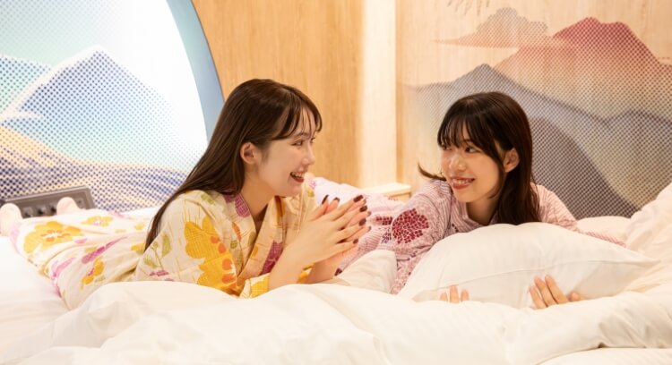 お部屋のキングサイズベッドでくつろぐ女性2人の様子